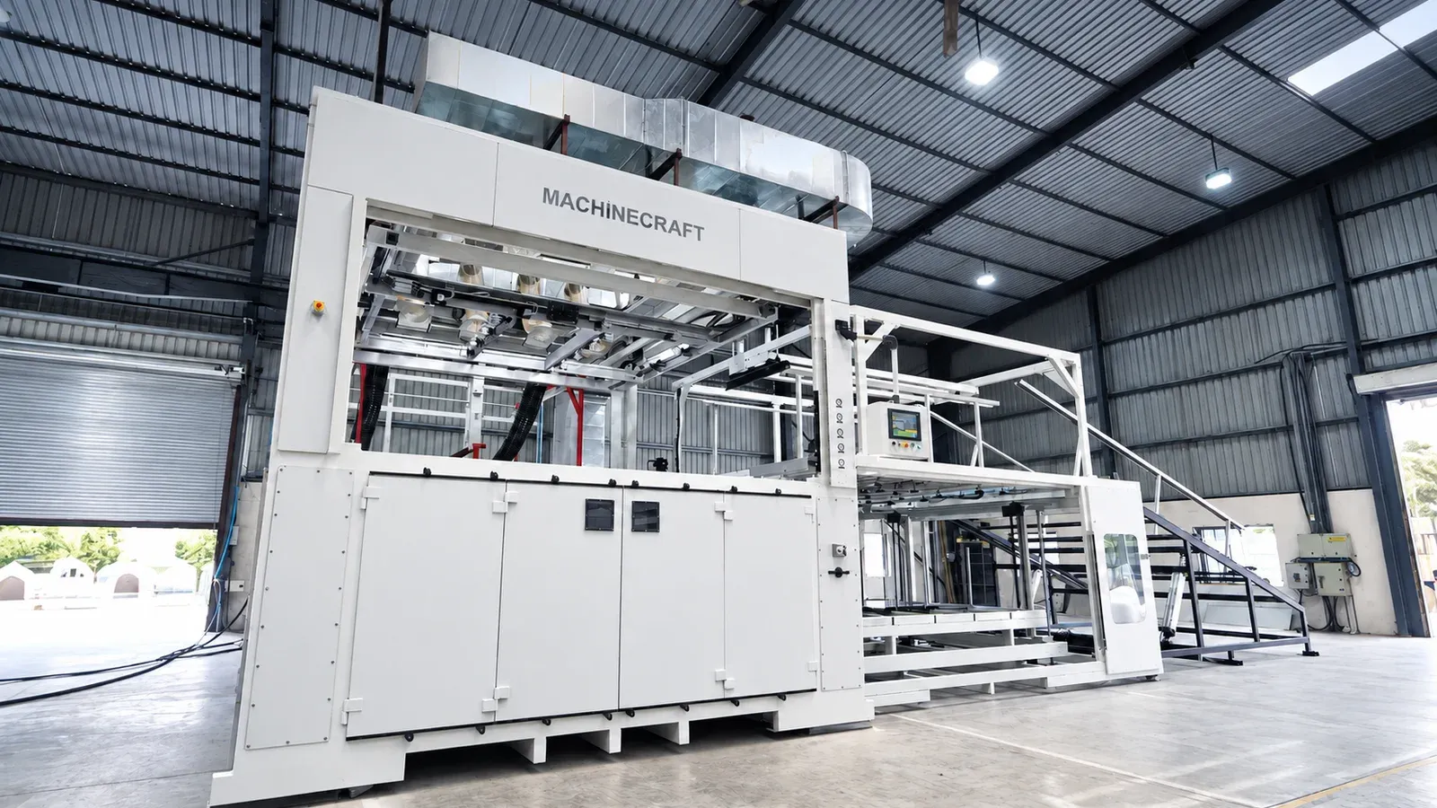 Heavy gauge thermoforming machine with a sheet handling frame inside a Machinecraft factory